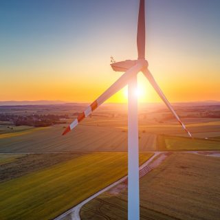 Beautiful sunset above the windmills on the field