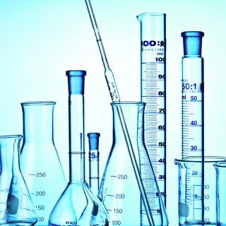 Flask, Measuring Cylinders, Glass Mug and pipette in laboratory.