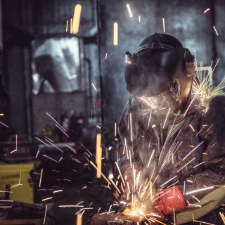 Industrial Worker laborer at the factory welding steel structure